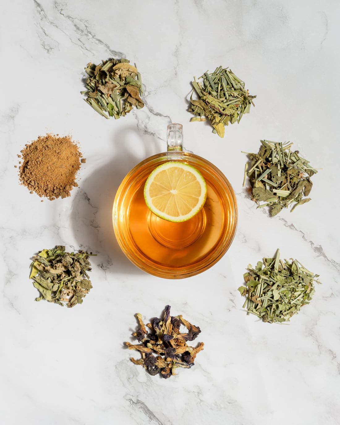 A cup of Layla Tea surrounded by whole botanicals